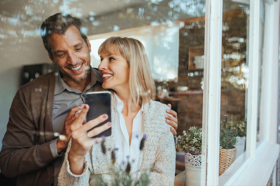 Client Center - Couple Looking at their Policy Through their Phone