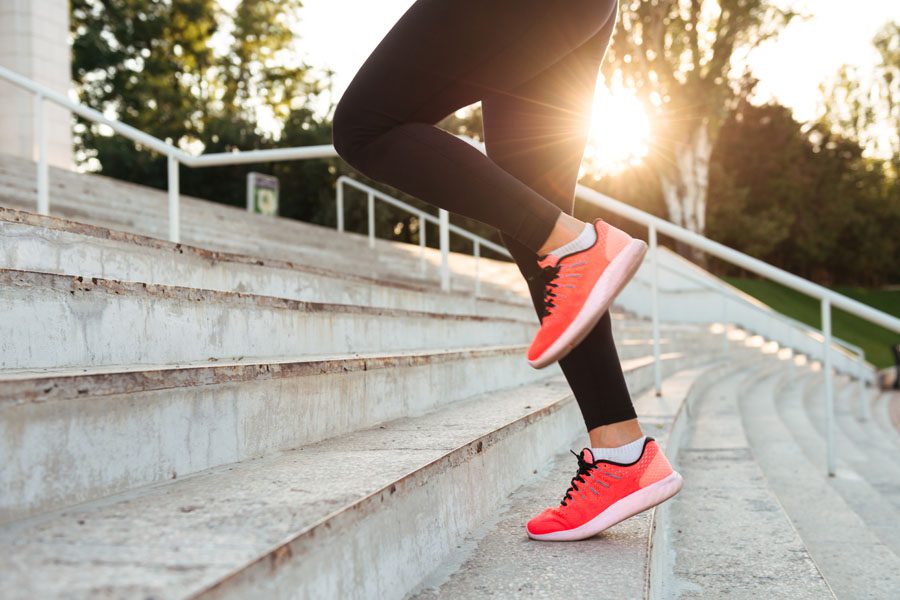 Employee Benefits - Woman Running Up Stairs for a Workout in the Sun